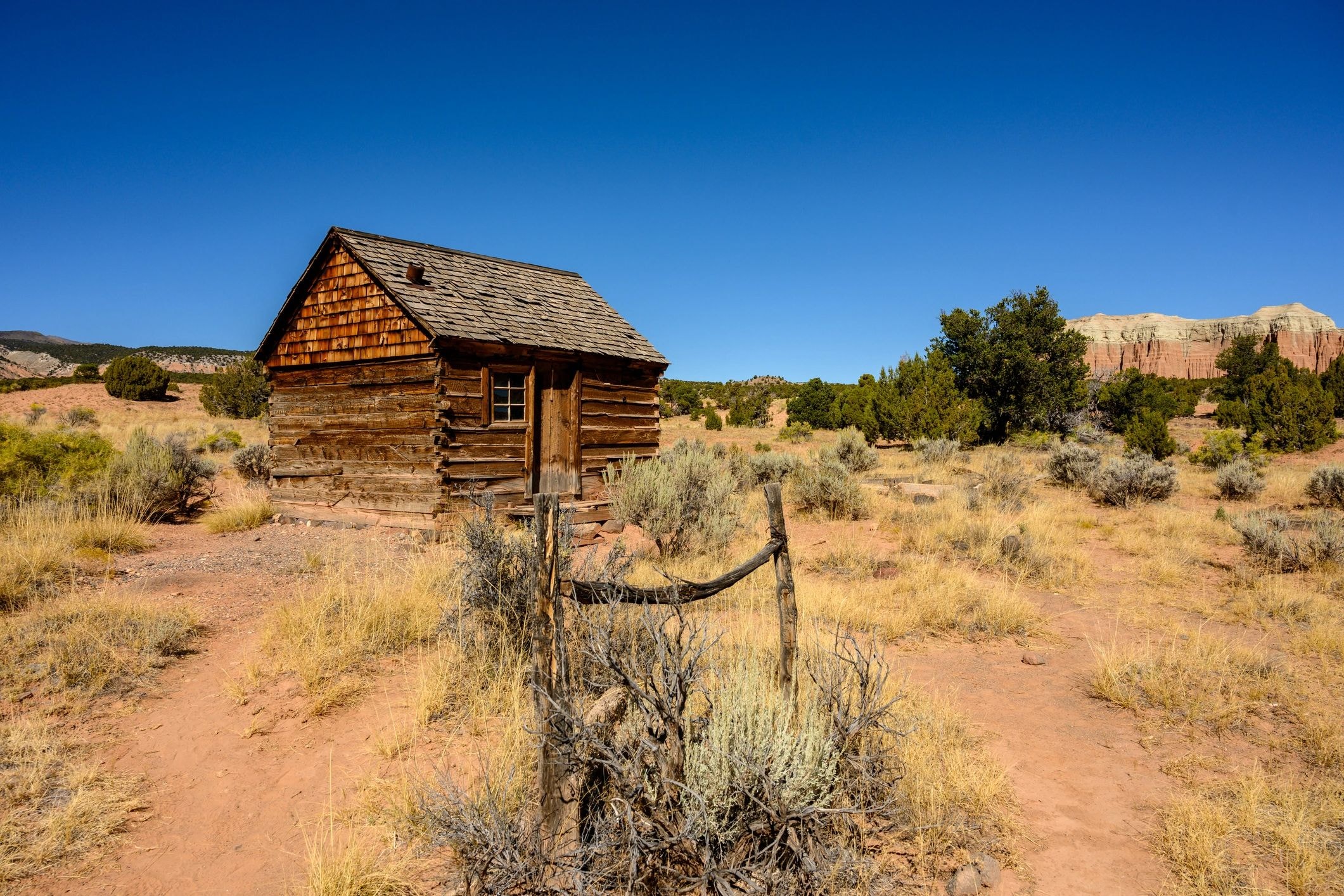 Weathered frontier cabin in a desert landscape